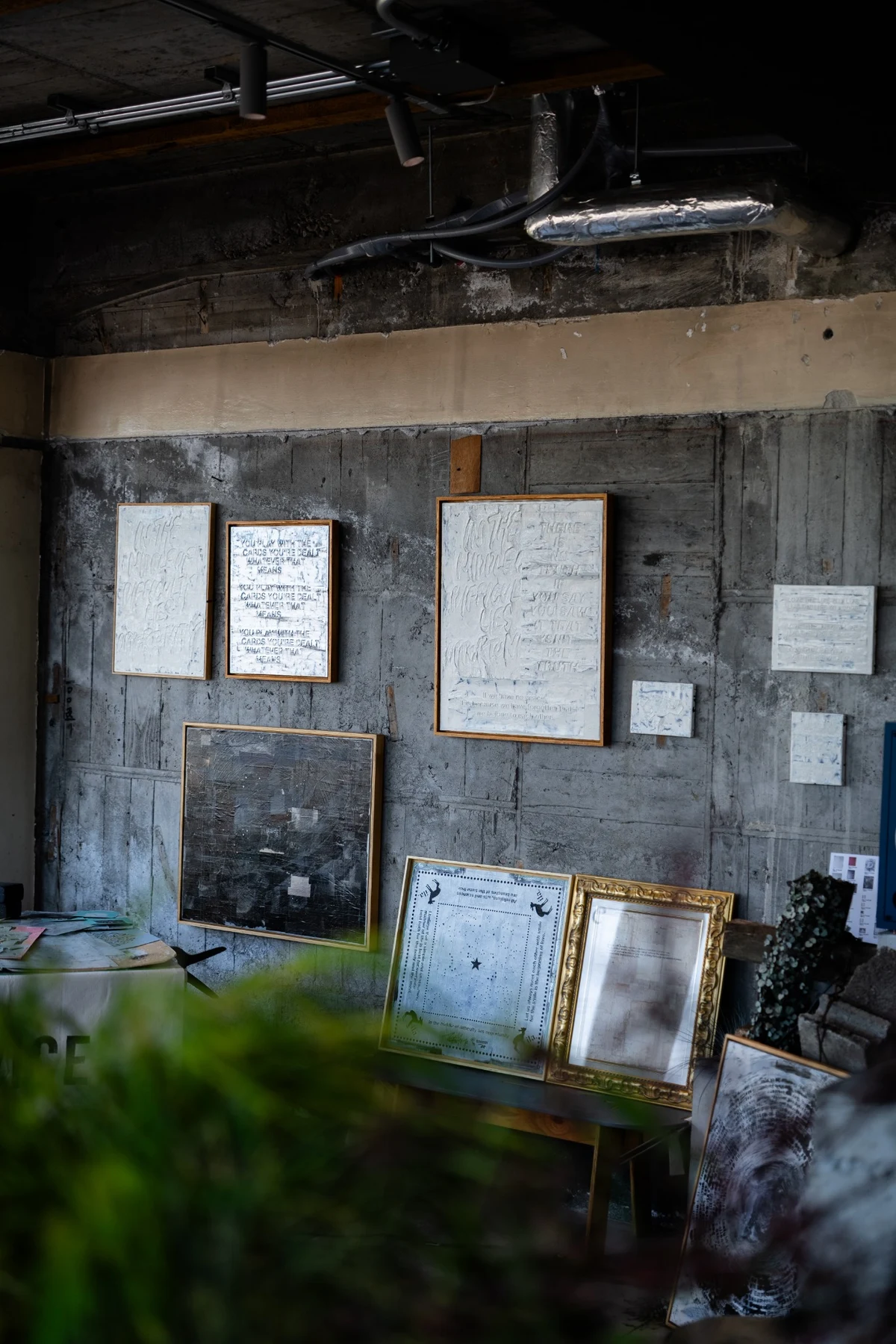 sceneの壁と棚に並ぶ守矢努の額装作品